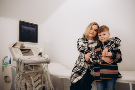 A mother hugs her son at the doctor's officeの写真素材