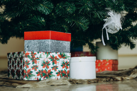 Beautiful Christmas gifts under fir tree on floor in roomの写真素材