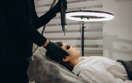 Laser removal of permanent makeup. The beautician removes the tattoo from the lips.の写真素材