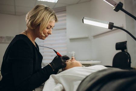 Permanent makeup on eyebrows by professional cosmetologist.
