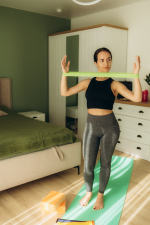 Woman exercising with rubber band at homeの写真素材