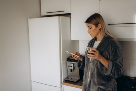 Young woman enjoying fresh aromatic coffee near modern machine in kitchenの写真素材