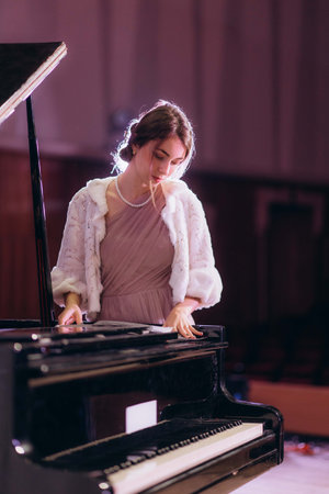 A woman on stage before a concert repeats notes at the pianoの写真素材