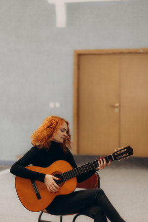 Relaxed redhead woman playing guitarの写真素材
