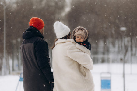 Father walks with his little daughters and teen-son in a forest in winterの写真素材