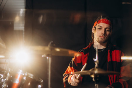Repetition of rock music band. Drummer behind the drum set. Rehearsal base