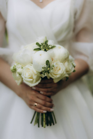 Very beautiful wedding bridal bouquet, made of white roch and austoma, and yellow daisies, green casting of eucalyptus. Wedding, engagement. Bride and groom. Bride's wedding bouquet.の写真素材