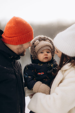 Portrait of a child in the arms of parents in winter