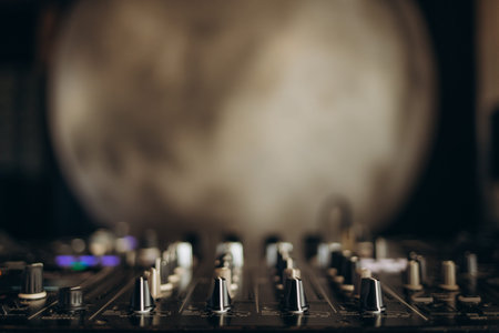 Blurred close-up of a professional audio mixing equipment with a textured background, creating an...