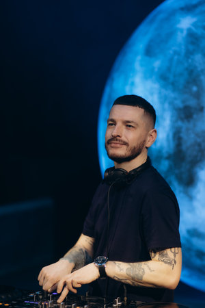 A DJ performing live in front of a futuristic background, creating an energetic atmosphere. The image captures the passion and skill of the artist while highlighting their connection to the audience.の写真素材