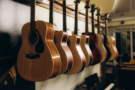 A collection of acoustic guitars elegantly displayed in a music shop, showcasing craftsmanship and design. Perfect for music enthusiasts and instrumental studies.の写真素材