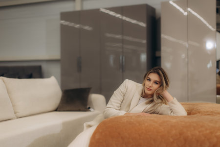 A stylish woman in a cozy setting, lounging on a sofa in a modern living space.の写真素材