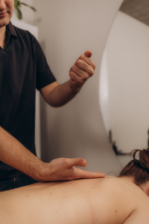 A professional therapist applies therapeutic techniques with oils during a relaxing massage session in a spa setting, providing relaxation and wellness benefits to the recipient.の写真素材