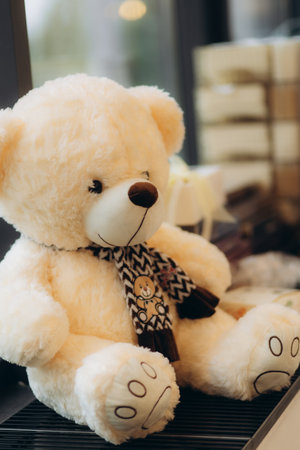 A cozy teddy bear dressed in a stylish patterned scarf displayed indoors. Evokes feelings of comfort and warmth in a decorative setting.の写真素材