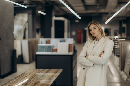 Elegant woman in a contemporary showroom, showcasing a confident and professional demeanor, perfect for modern business themes.の写真素材