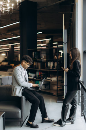 A professional setting showcasing colleagues collaborating and engaging with technology, emphasizing teamwork and productivity in a stylish and modern workspace.の写真素材