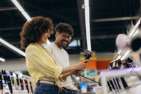 Couple enjoying their time shopping for electronic hairdryers in a well-lit store.
