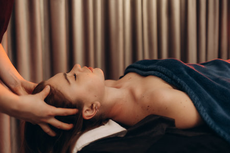 A serene moment of someone receiving a soothing head massage with relaxing ambiance.の写真素材