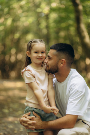 A heartfelt moment of a father and his young daughter bonding in a natural setting. The scene...