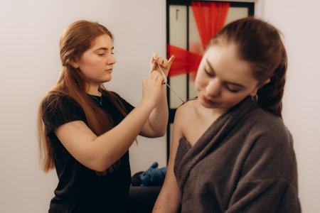 A professional provides assistance during a beauty therapy session, ensuring attention to detail amidst a comfortable environment.の写真素材