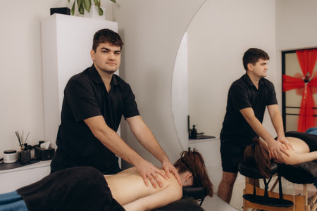 A skilled male therapist performing a relaxing back massage on a client in a tranquil spa environment, emphasizing wellness and personalized care.の写真素材