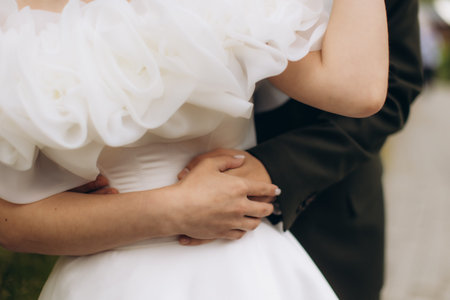 Couple hugging during wedding ceremony. Groom's arms wrapping bride, symbolizing romance, commitment, and partnershipの写真素材