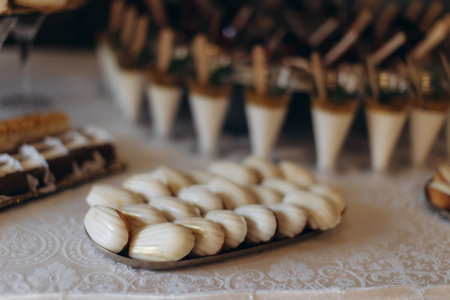 Madeleines, pastries, and sweet desserts artfully arranged on a white tablecloth, perfect for...