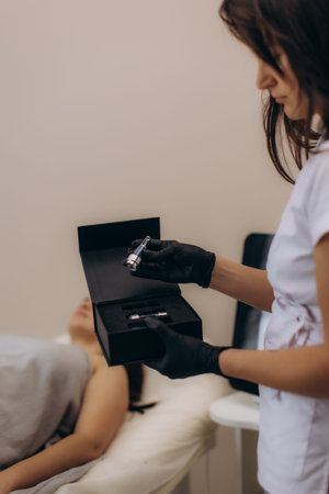 Professional beautician holding a box of skin care ampoules, preparing for a cosmetic treatment with...