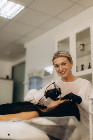 Cosmetologist applying permanent makeup to woman's lips, providing beauty treatment in a salon...