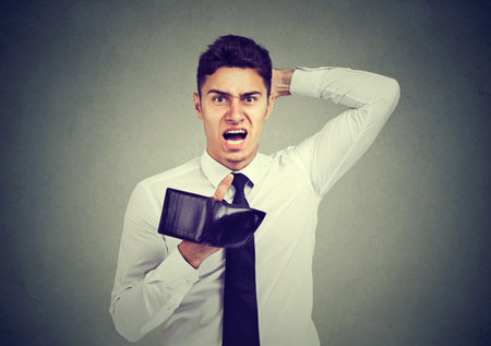 Portrait of a shocked, frustrated angry man, holding an empty wallet