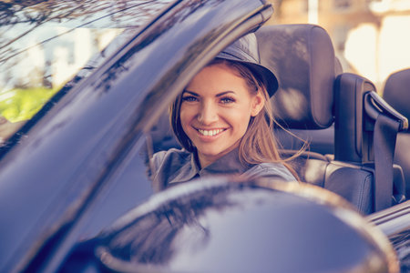 Happy woman driving convertible on a sunny autumn day