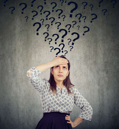 Young thoughtful woman with too many questions thinking hardの写真素材