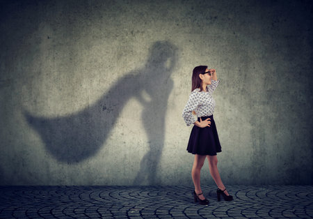 Side view of a business woman imagining to be a super hero looking aspired.