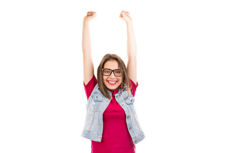 Young super excited woman in glasses holding hands fists up celebrating success feeling happy on...