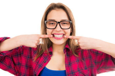 Young happy woman in glasses smiling wide and showing perfect white teeth looking at camera isolated...
