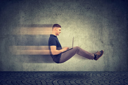 Fast internet concept. Levitating business man on road using laptop
