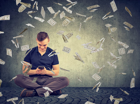 Young man sitting and using smartphone winning huge amount of money in Internet.