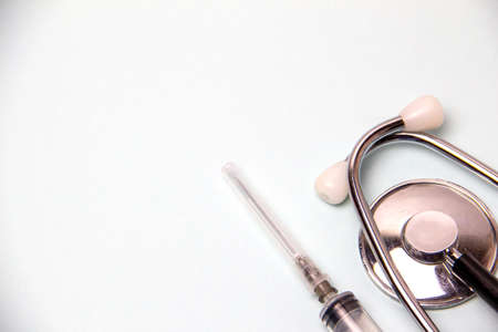 Medical flat lay. Phonendoscope, pills, syringe, ampoules for the treatment and diagnosis of disease and coronavirus virus on a gray background.の写真素材