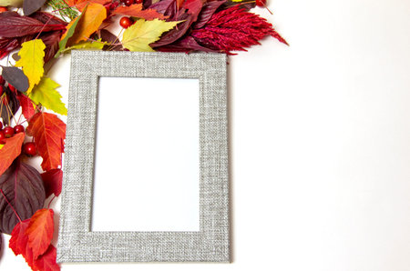 Photo frame of gray color among colorful autumn leaves. Autumn mood, top view, place for text,...