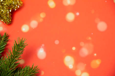 christmas red background, coniferous branch with christmas tree toy, copy space, top viewの写真素材