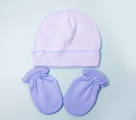mittens-bags and blue cap for newborns on a gray background. Birth of a child. buying clothes for newbornsの写真素材