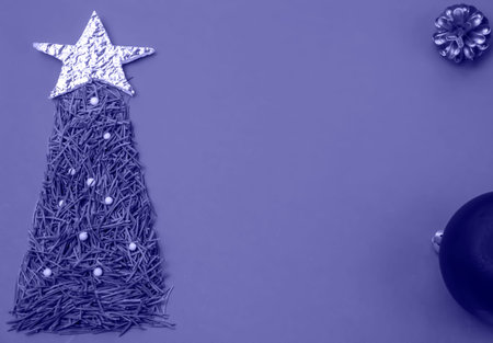 christmas lilac 17-3938 Very Peri background, fir tree made of pine needles with a silver star on a background, christmas-tree toy copy space, top viewの写真素材