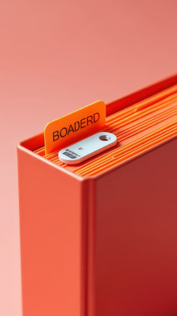 Orange file organizer with usb drive and tabbed dividers in modern office setup.の素材