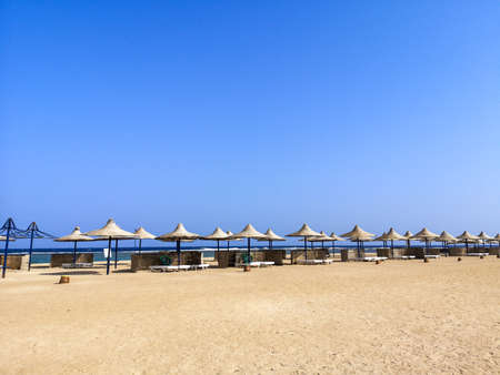 View on great sandy beach in Marsa Alam, Egypt with umbrellas and sun loungers, sunny summer day. High quality photoの写真素材
