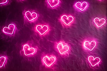 Valentine's day background. Neon pink heart on white fur.の写真素材
