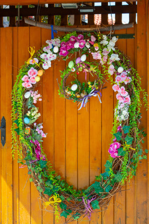 Easter Eggs wreath with flowers on front door. Traditional decoration for Easter. . high quality photoのeditorial素材