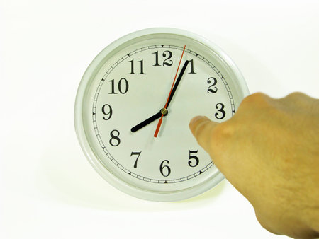 A man pointing to the clock showing a little past 8.