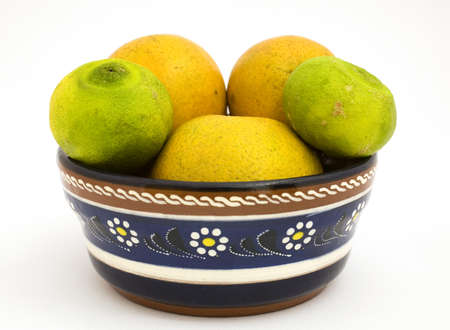 3 oranges and 2 limes in a bowの写真素材