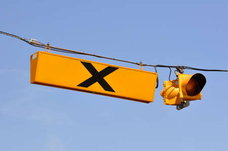 Yellow railroad crossing sign and traffic lightの写真素材