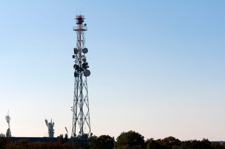 Telecommunications tower with antennas under blue sunset skies.のeditorial素材